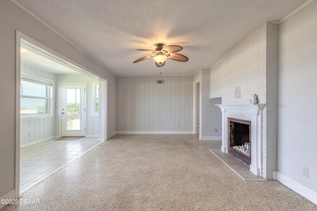 3622 Ocean Shore Blvd, Ormond Beach, FL 32176 - unfurnished living room featuring a ceiling fan, a brick fireplace, speckled floor, and crown molding