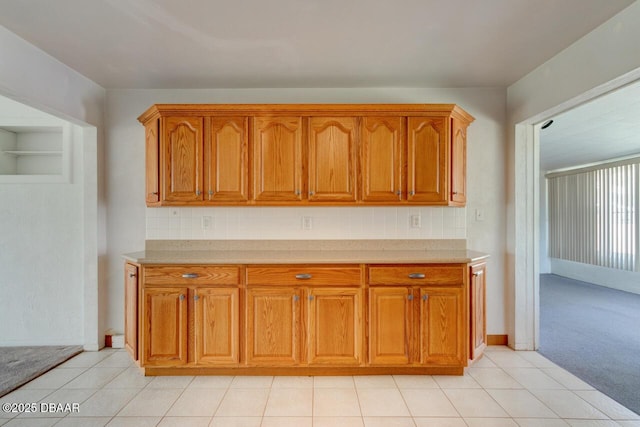 37 Berkley Rd, Ormond Beach, FL 32176 - kitchen featuring light countertops, brown cabinets, light tile patterned floors, and backsplash
