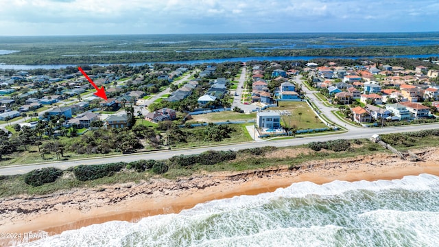 drone / aerial view with a water view and a view of the beach