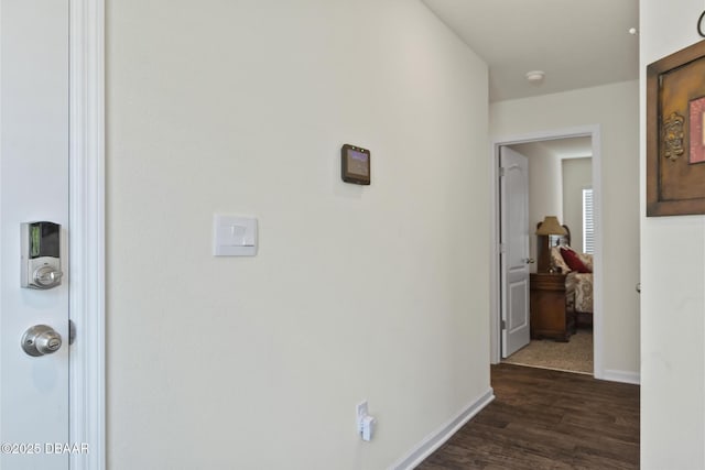 corridor with dark hardwood / wood-style flooring