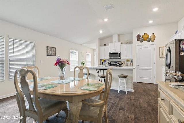 dining room with lofted ceiling and dark wood-type flooring