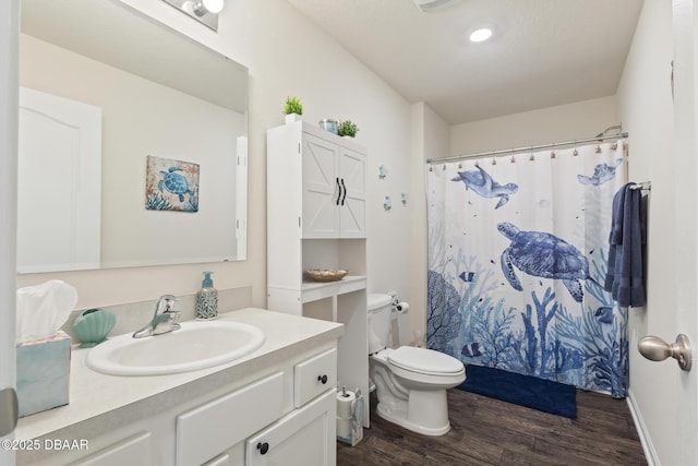 bathroom featuring hardwood / wood-style floors, vanity, curtained shower, and toilet