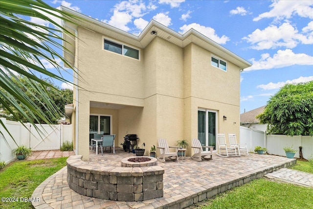 back of house featuring a patio and a fire pit