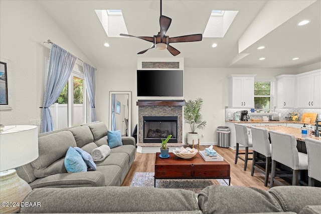 living room featuring light hardwood / wood-style flooring, lofted ceiling, and ceiling fan