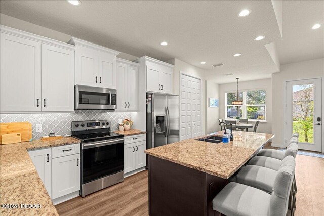 kitchen featuring white cabinets, light hardwood / wood-style floors, stainless steel appliances, and sink