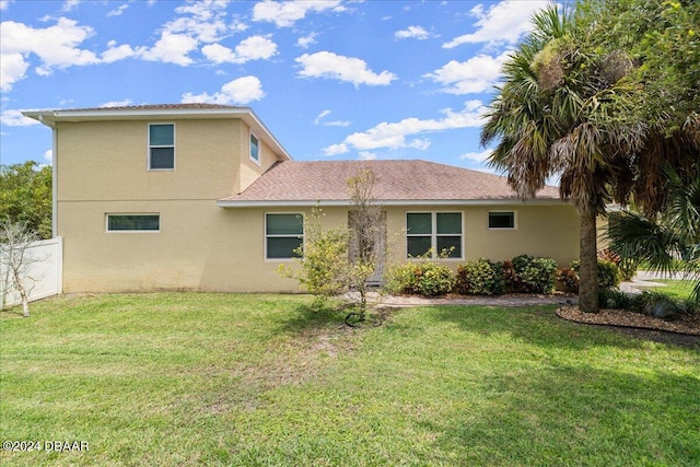 rear view of property featuring a lawn