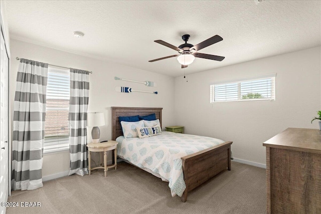 carpeted bedroom with a textured ceiling and ceiling fan