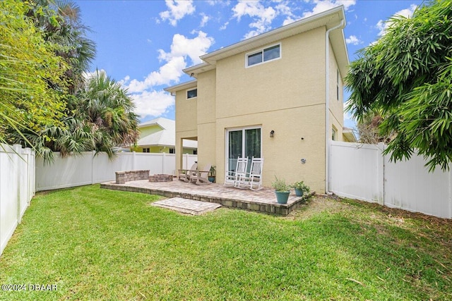 back of property with a patio and a lawn