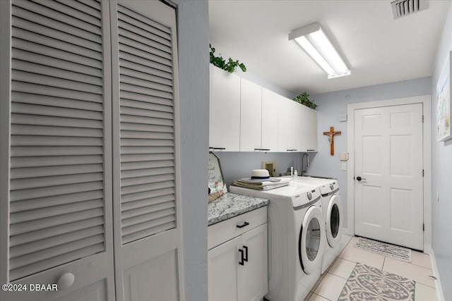 washroom with cabinets, independent washer and dryer, and light tile patterned floors