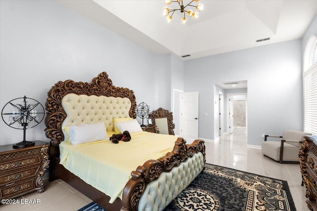 bedroom featuring light tile patterned flooring, a tray ceiling, and a notable chandelier