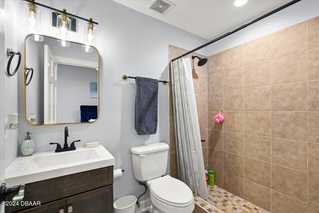 bathroom with toilet, vanity, and a shower with shower curtain