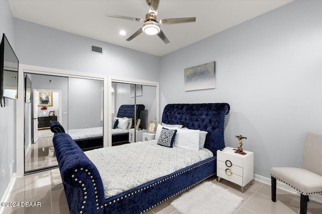 bedroom featuring multiple closets, ceiling fan, and light tile patterned floors