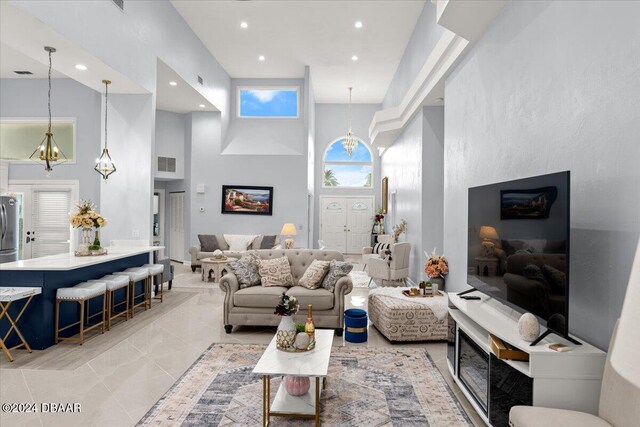 living room featuring a chandelier and a towering ceiling