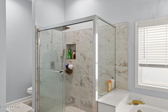 bathroom featuring toilet, independent shower and bath, and a wealth of natural light