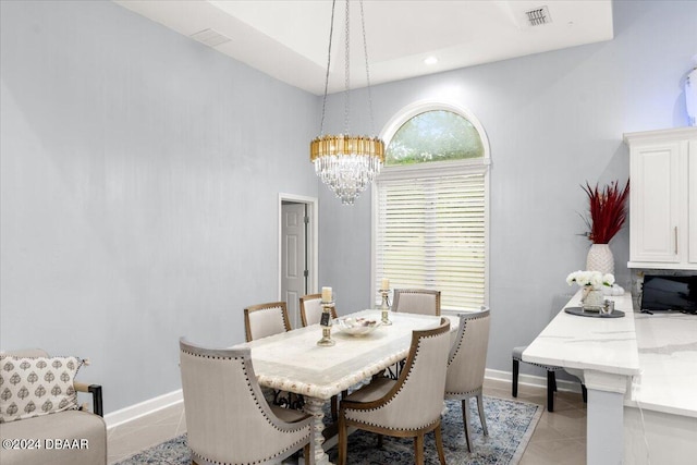 dining area with a notable chandelier, light tile patterned flooring, and a high ceiling