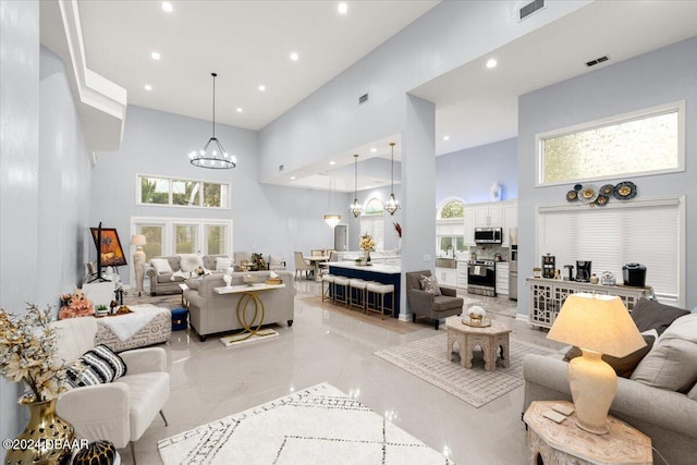 living room featuring sink, an inviting chandelier, and a towering ceiling