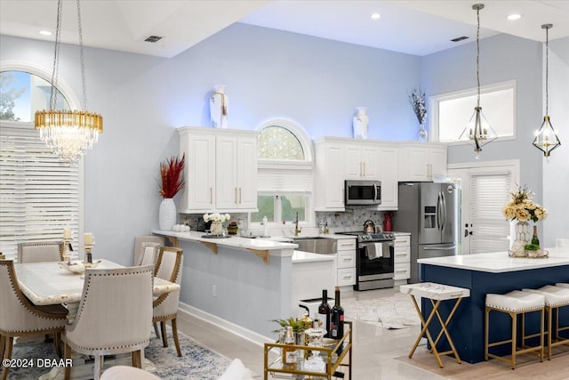 kitchen with stainless steel appliances, a kitchen breakfast bar, and white cabinetry