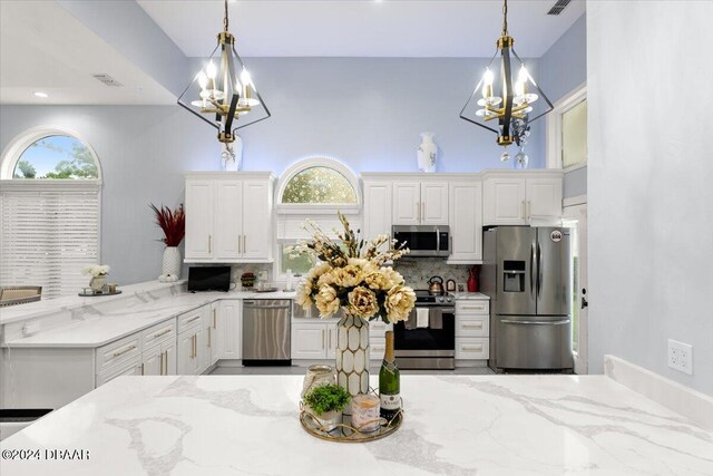 kitchen featuring white cabinetry, pendant lighting, appliances with stainless steel finishes, and tasteful backsplash