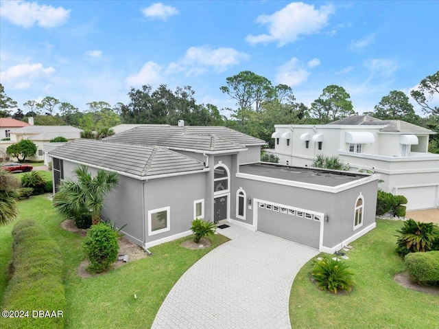 view of front of house with a garage and a front lawn