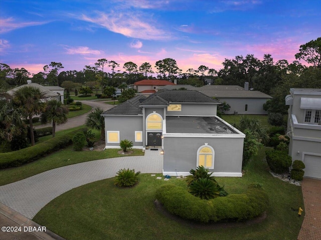 view of front of property with a garage and a lawn