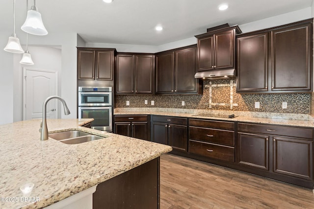 115 Pergola Pl, Ormond Beach, FL 32174 - kitchen featuring stainless steel double oven, decorative light fixtures, light stone countertops, dark brown cabinetry, and recessed lighting