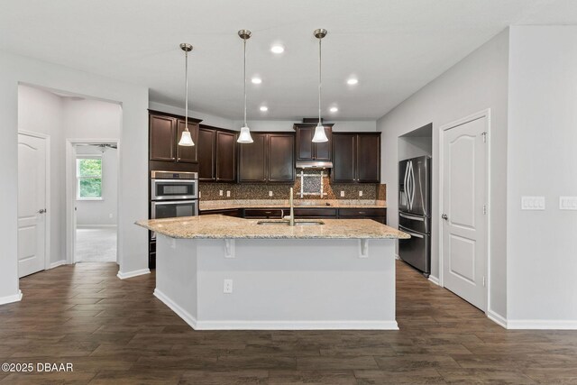 115 Pergola Pl, Ormond Beach, FL 32174 - kitchen with stainless steel appliances, dark brown cabinetry, backsplash, a center island with sink, and recessed lighting