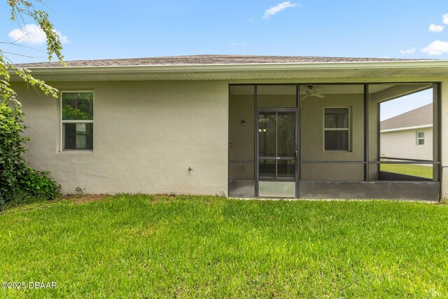 115 Pergola Pl, Ormond Beach, FL 32174 - rear view of property featuring a sunroom, stucco siding, a yard, and a ceiling fan