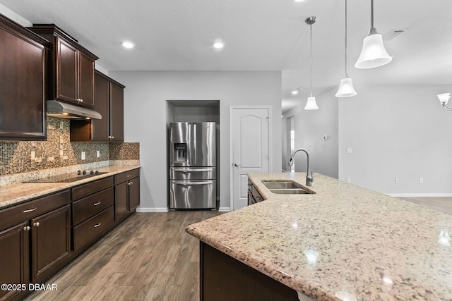 115 Pergola Pl, Ormond Beach, FL 32174 - kitchen featuring stainless steel fridge, under cabinet range hood, black electric cooktop, decorative backsplash, and wood finished floors