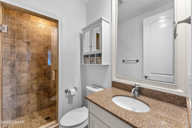 full bathroom with vanity, a shower stall, and toilet