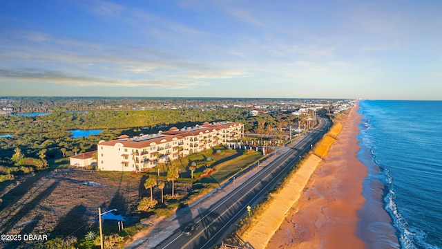 drone / aerial view featuring a water view and a beach view