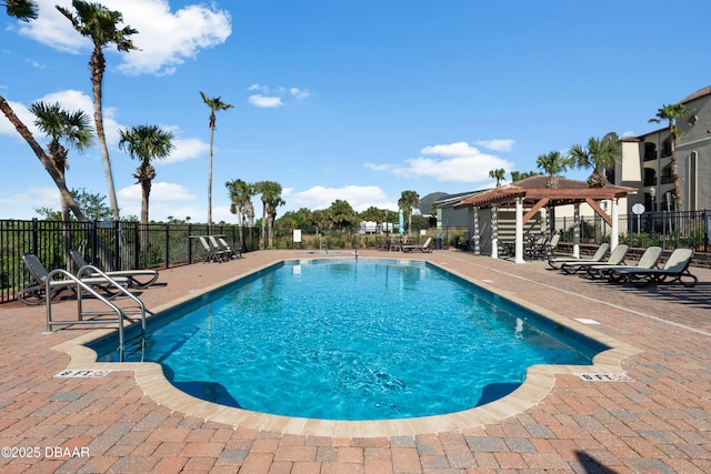 community pool with fence and a patio
