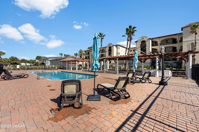 community pool featuring a patio area, fence, and a pergola