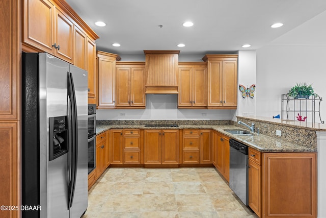 kitchen with brown cabinets, appliances with stainless steel finishes, a sink, a peninsula, and custom range hood