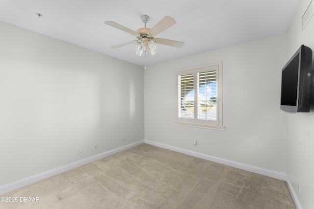 spare room featuring carpet floors, a ceiling fan, and baseboards