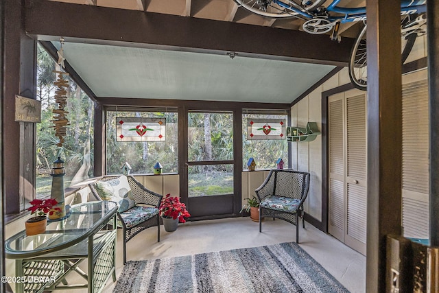 sunroom featuring lofted ceiling with beams