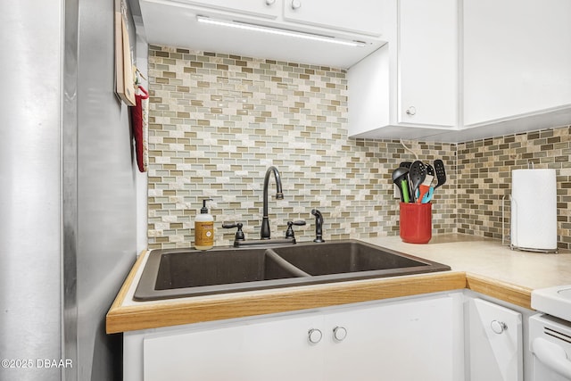 kitchen with sink, white cabinetry, and backsplash