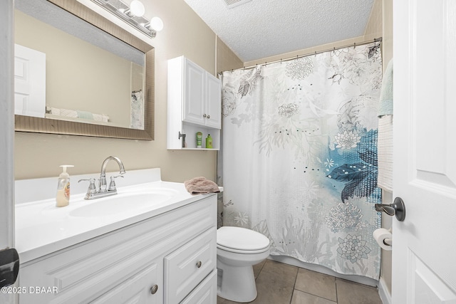 bathroom with tile patterned flooring, vanity, a textured ceiling, and toilet