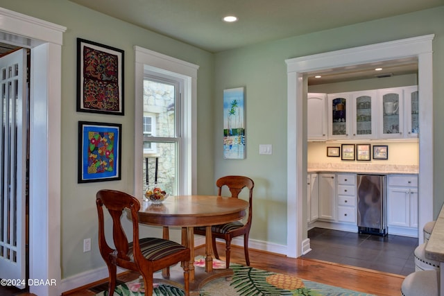 dining area featuring bar, dark wood-type flooring, and wine cooler