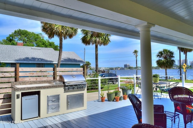 wooden deck featuring a water view and area for grilling