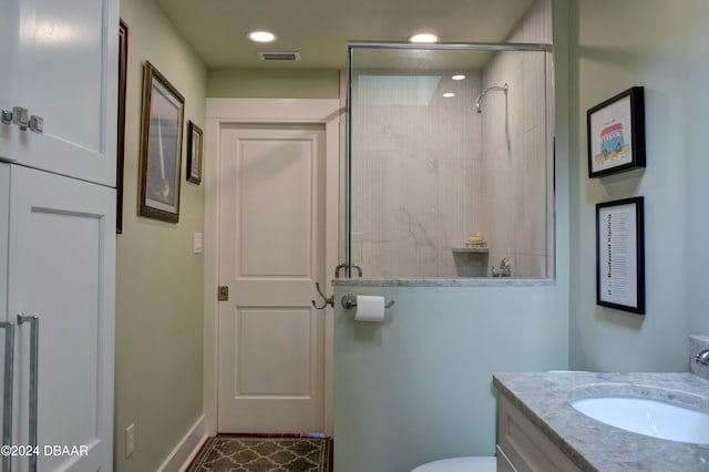 bathroom featuring toilet, vanity, and walk in shower