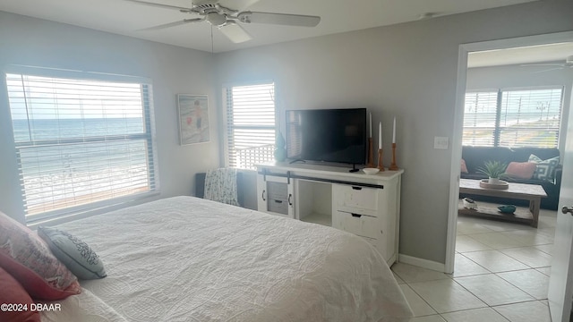 bedroom featuring multiple windows, light tile patterned floors, and ceiling fan