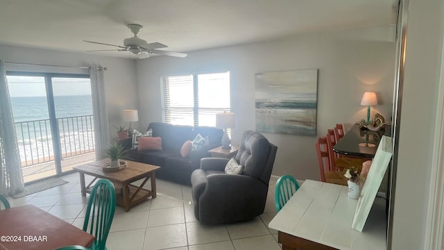 tiled living room featuring a water view and ceiling fan