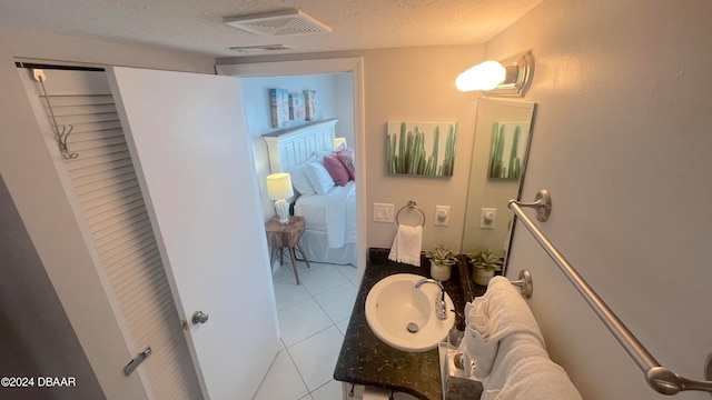 bathroom featuring tile patterned flooring, vanity, and a textured ceiling