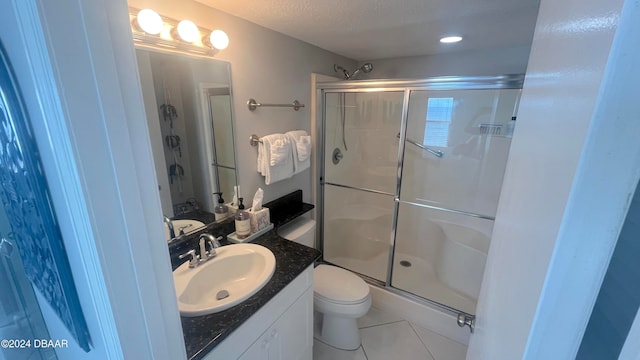 bathroom with vanity, tile patterned floors, toilet, and a shower with door