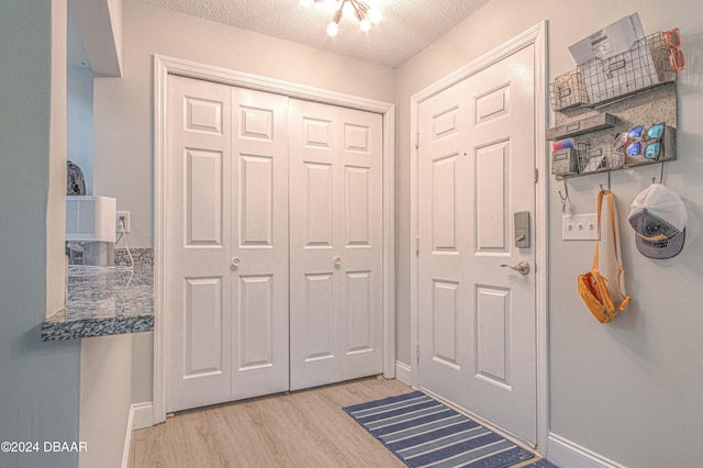 foyer entrance featuring light hardwood / wood-style flooring and a textured ceiling