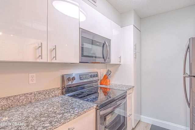 kitchen featuring white cabinets, appliances with stainless steel finishes, and a textured ceiling