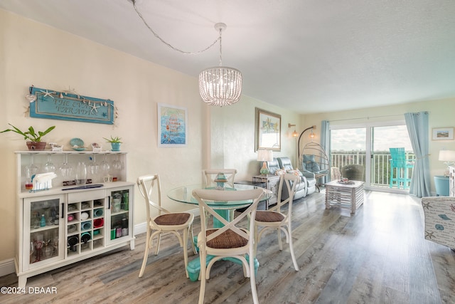 dining area with hardwood / wood-style floors and an inviting chandelier