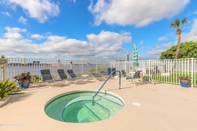 view of pool featuring a patio area, a community hot tub, and a water view