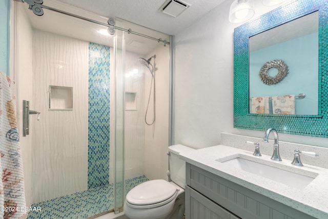 bathroom with a textured ceiling, vanity, toilet, and a shower with shower door