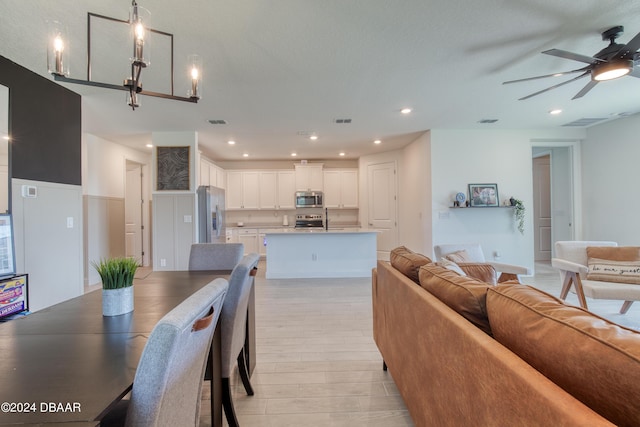 dining area with recessed lighting, visible vents, light wood finished floors, and ceiling fan with notable chandelier